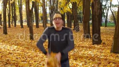 有趣的家伙扔了一堆枫叶，像狗一样快乐在秋天的公园。 <strong>阳光</strong>明媚的一天，一片树叶飘落在<strong>小镇</strong>上